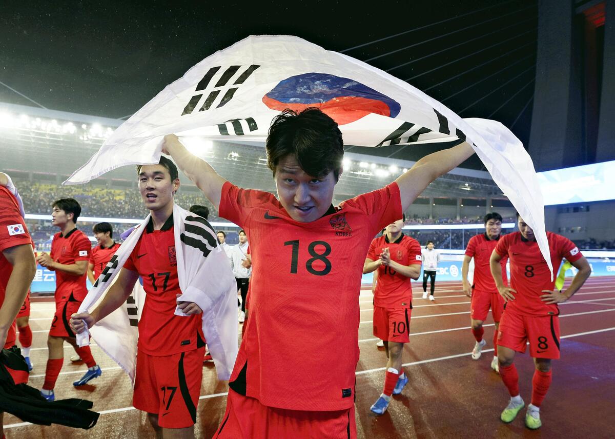２０２３年の杭州アジア大会サッカー男子。優勝し国旗を手にサポーターのスタンドへ向かう韓国代表選手たち