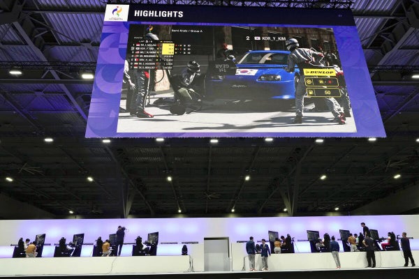 レーシングカーが映し出された会場の大型モニター（２３日）＝ＡＰ
