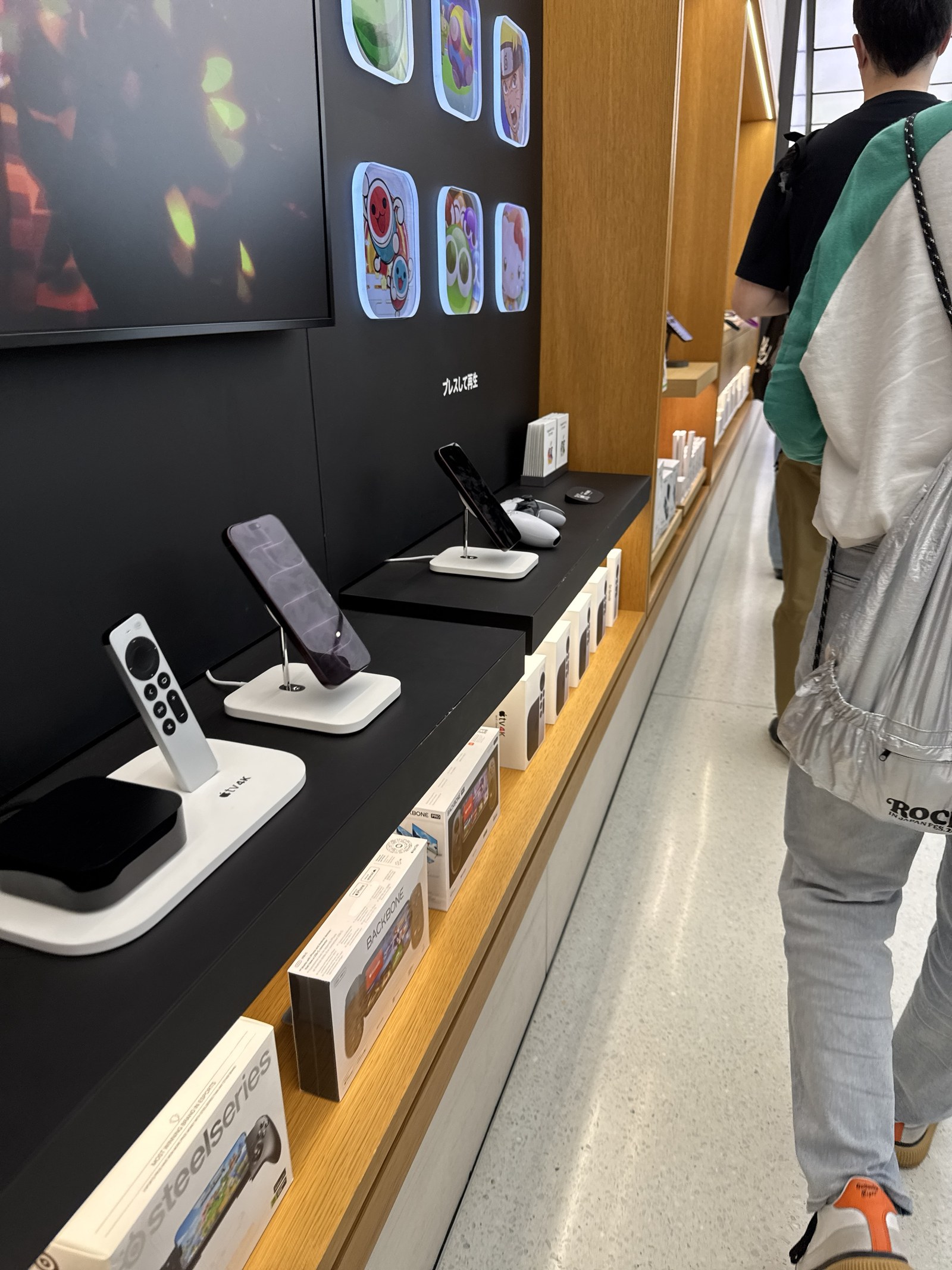 Apple TVやアクセサリーの展示棚の横を、受け取りの列がゆっくり進んでいく様子