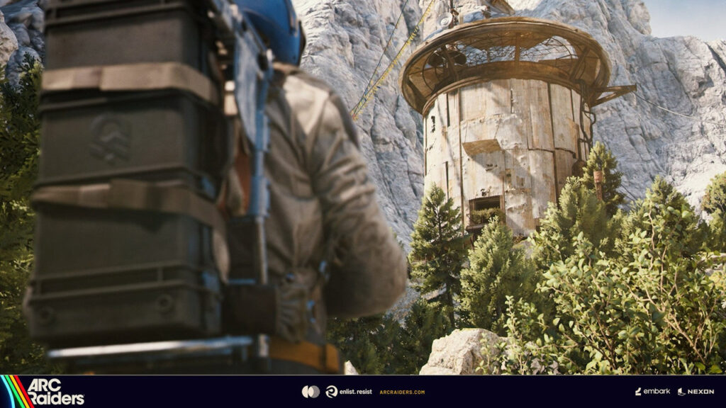 岩山のふもと、木々の間に建つ円筒形の建物を見上げるレイダー。『ARC Raiders』の拠点「The Outpost」
