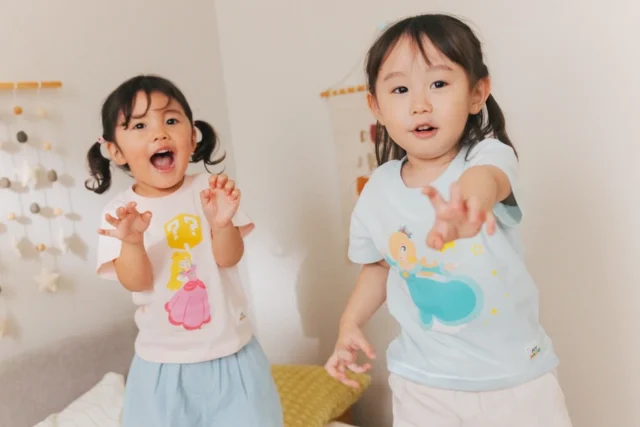 マリオのアパレルを着て手を広げる二人の子ども