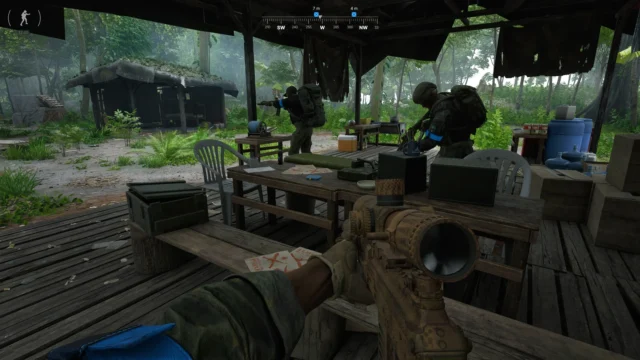 グレーゾーン ウォーフェアのゲーム画面。木造小屋で装備を持つ兵士と銃を構える一人称視点