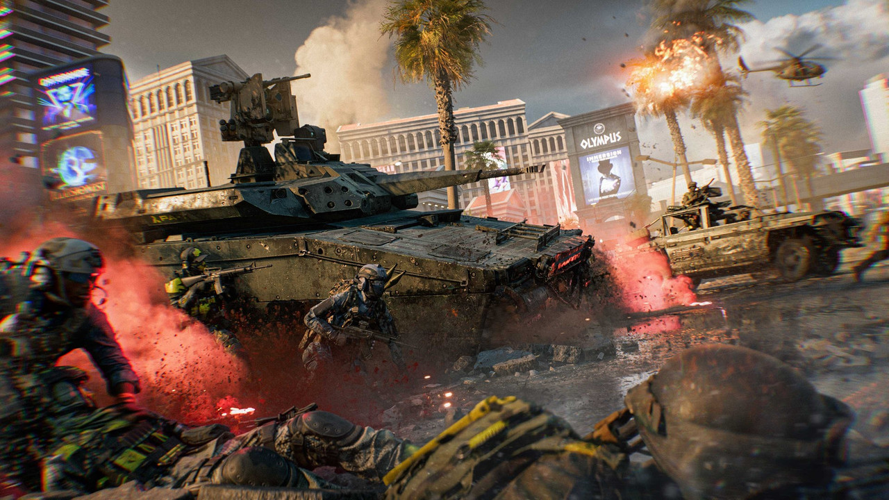 『Battlefield 6』「Vegas Strip」のスクリーンショット。赤い煙が漂う大通りを戦車が進み、周りで兵士が撃ち合う。奥に「OLYMPUS」の看板とヘリコプター