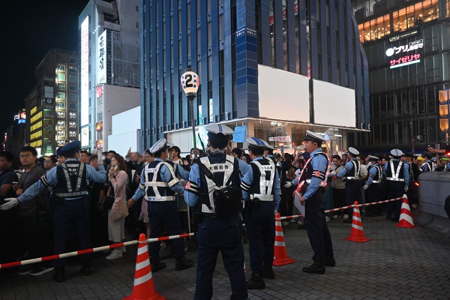 阪神ファンが集まる大阪・道頓堀。川の周辺には大阪府警の警察官たちが立ち並ぶ（10月3日、17時頃）